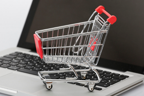 Miniature shopping cart resting on a laptop keyboard. Image credit:  Tim Reckmann, Flickr